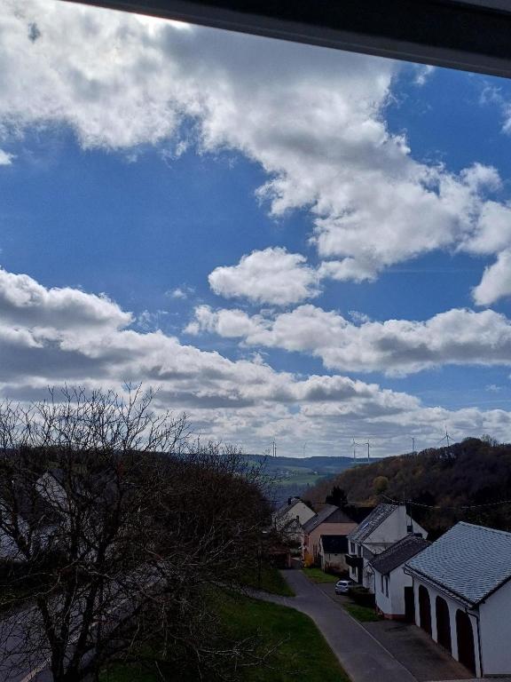 a view of a town with a blue sky and clouds at Ferienwohnung Talblick in Horath