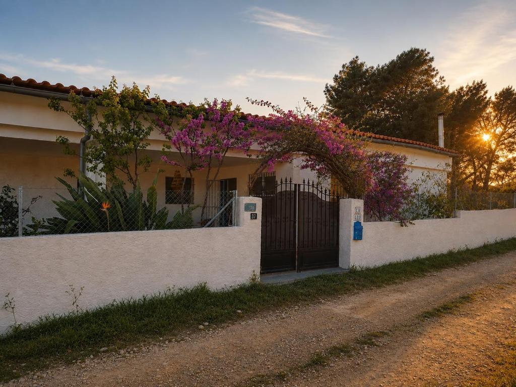ein weißes Haus mit einem Zaun und lila Blumen in der Unterkunft Ca Leo in Alicante