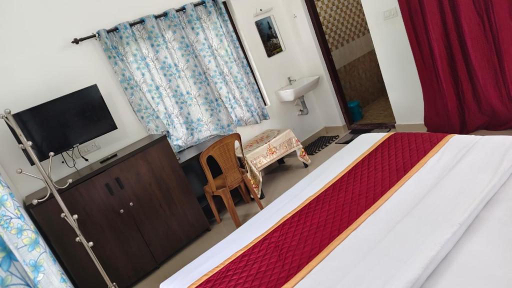 a bedroom with a bed and a flat screen tv at Trinity Homestay Munnar in Anachal