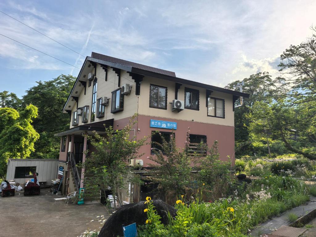 a house with a garden in front of it at 雪之宿 in Myoko