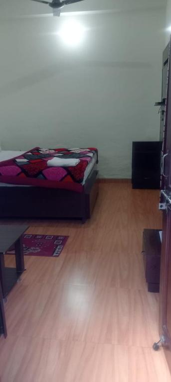 a room with a bed sitting on a wooden floor at Pragya inn hotel Haldwani in Haldwāni