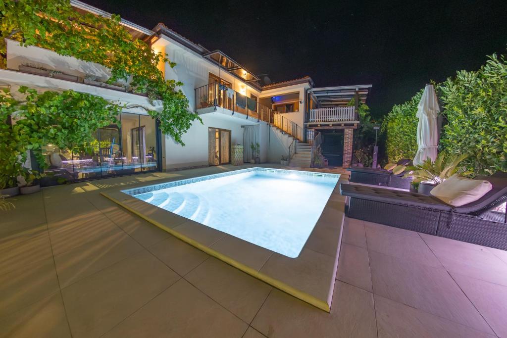 a swimming pool in the backyard of a house at night at Casa MiA in Linardići