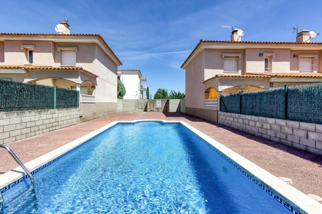a swimming pool in front of a house at Casa con piscina comunitaria in L'Escala