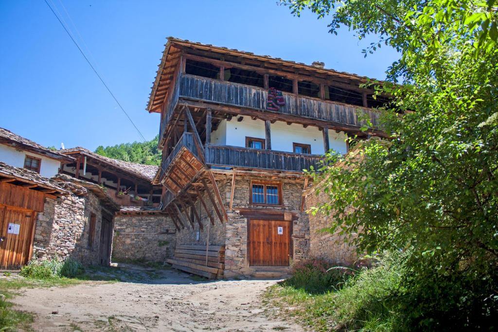 un edificio con balcone sopra di Kruchma Bratyata Guest House a Kovachevitsa