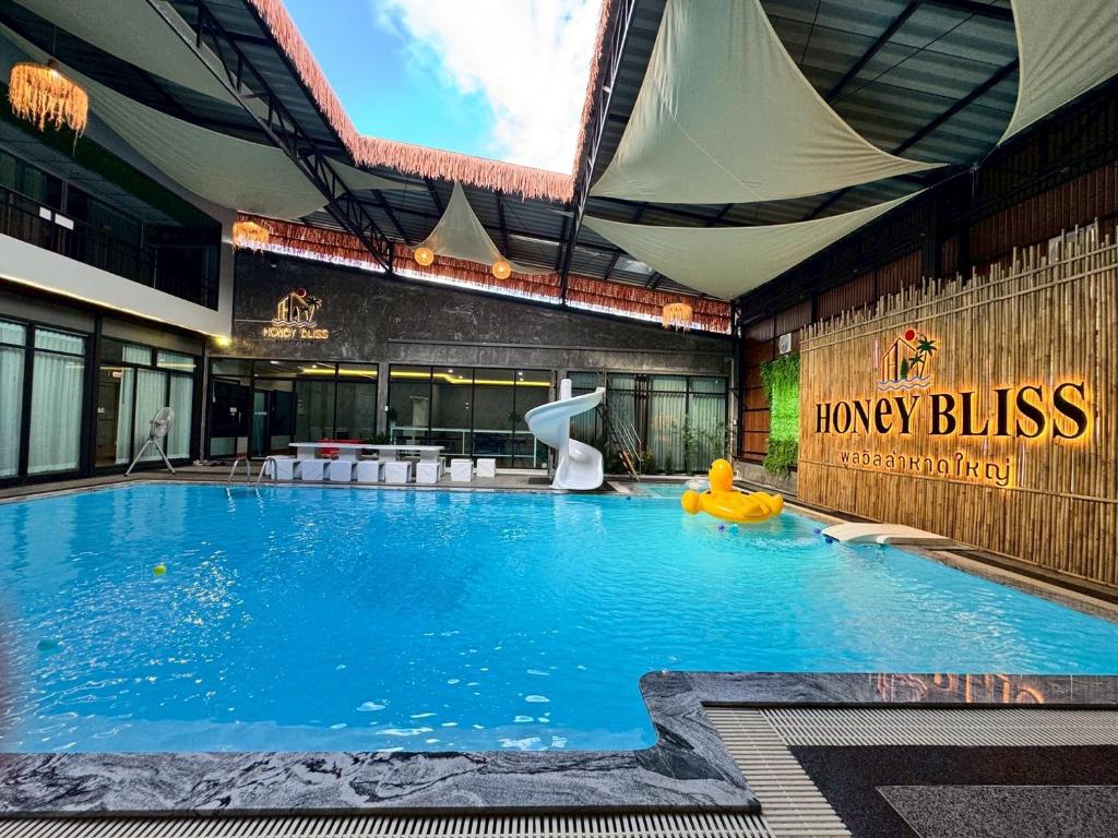 a large swimming pool with a yellow raft in a building at Honey Bliss Pool Villa in Hat Yai