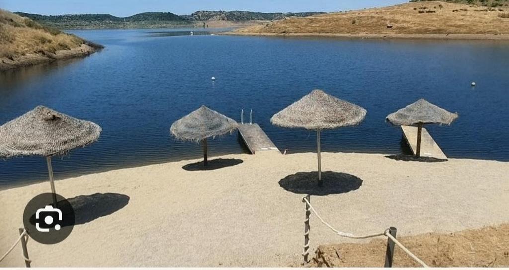 a group of umbrellas on a beach near the water at LaCasa DeLola in Almodóvar del Río