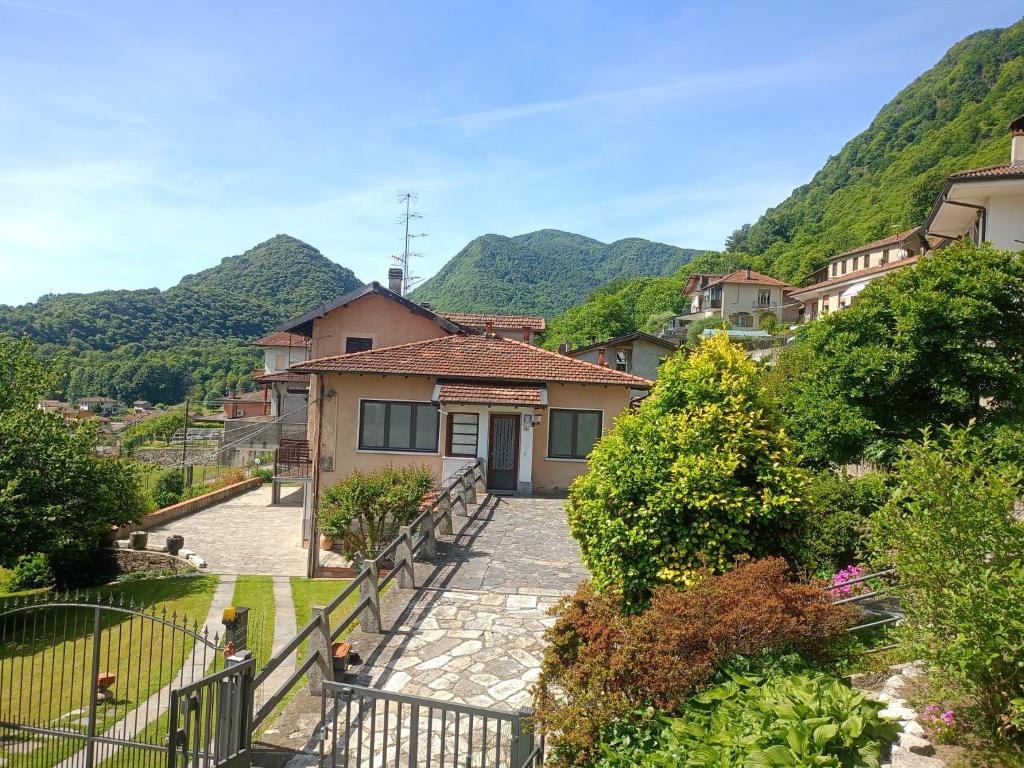 a house on a hill with mountains in the background at Casa Silvia Natura Relax, Sport & Family in Omegna