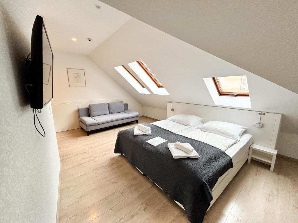 a bedroom with a bed and a tv and a couch at Erhardt Panzió in Sopron