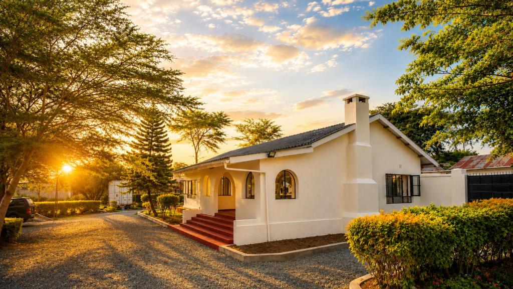 a small white house on a gravel road at Naisula Home in Naivasha