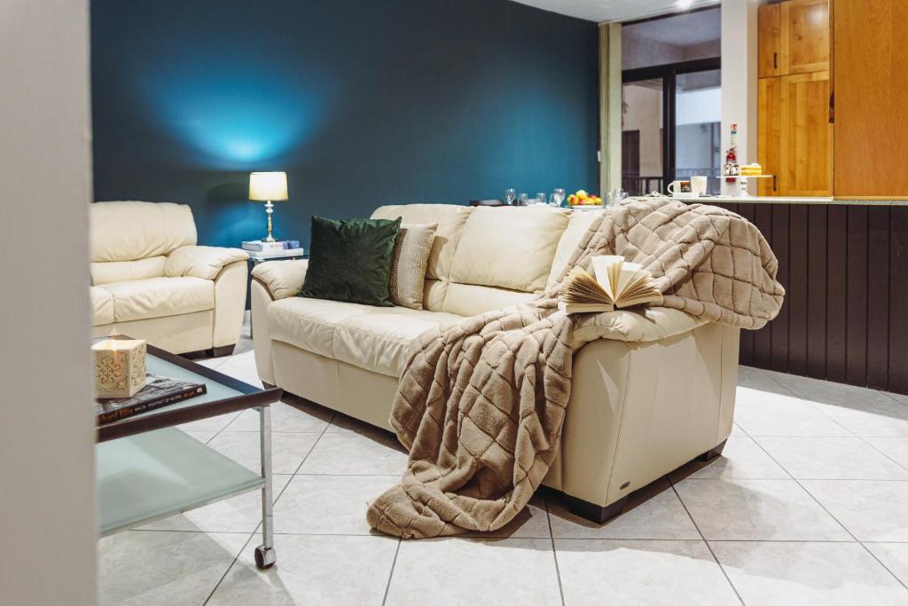 a living room with a couch with a blanket on it at Savoy Signature Stays in Il-Gżira