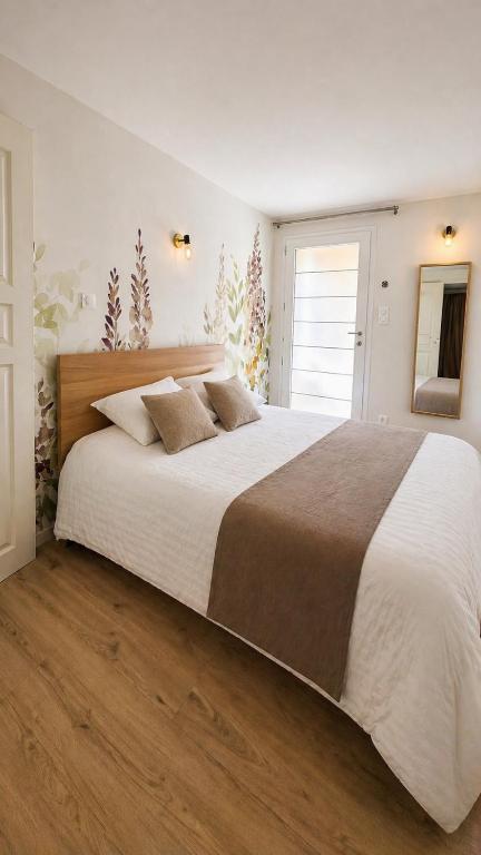 a large white bed in a bedroom with a window at Studio Cosy in Coussergues