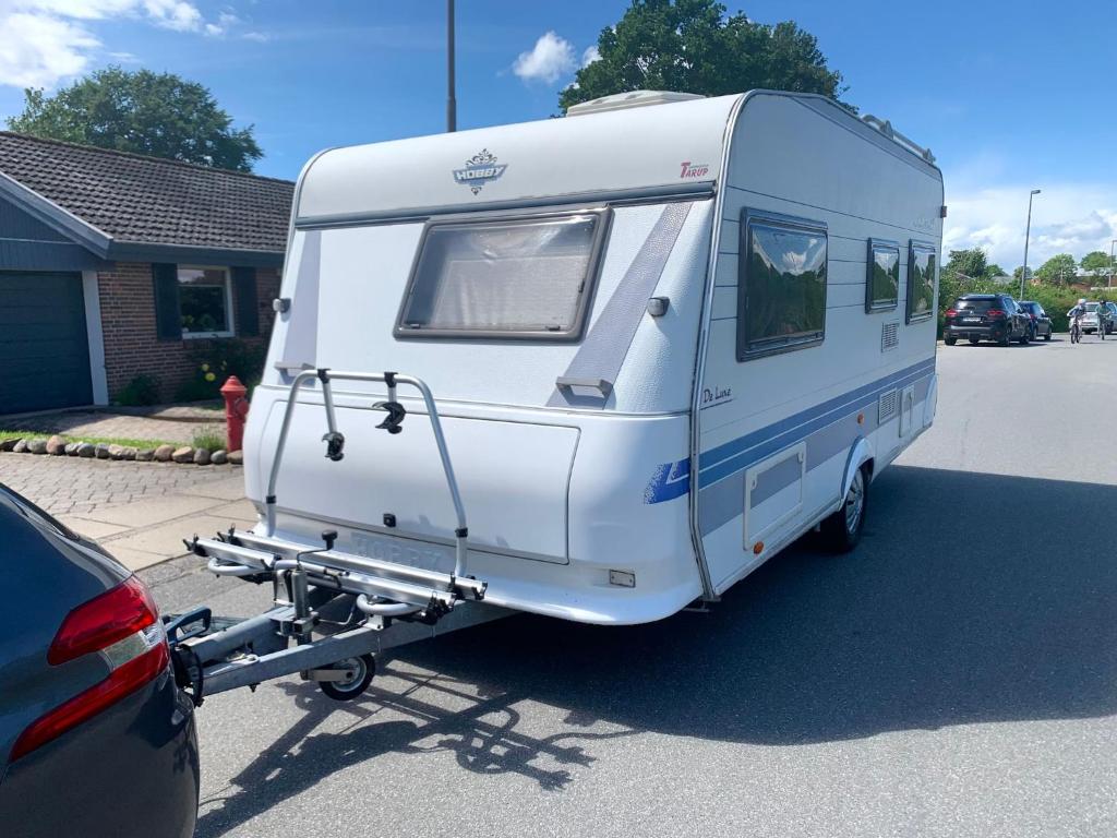 a white trailer is parked in a parking lot at Hobby De Luxe Caravan in Copenhagen