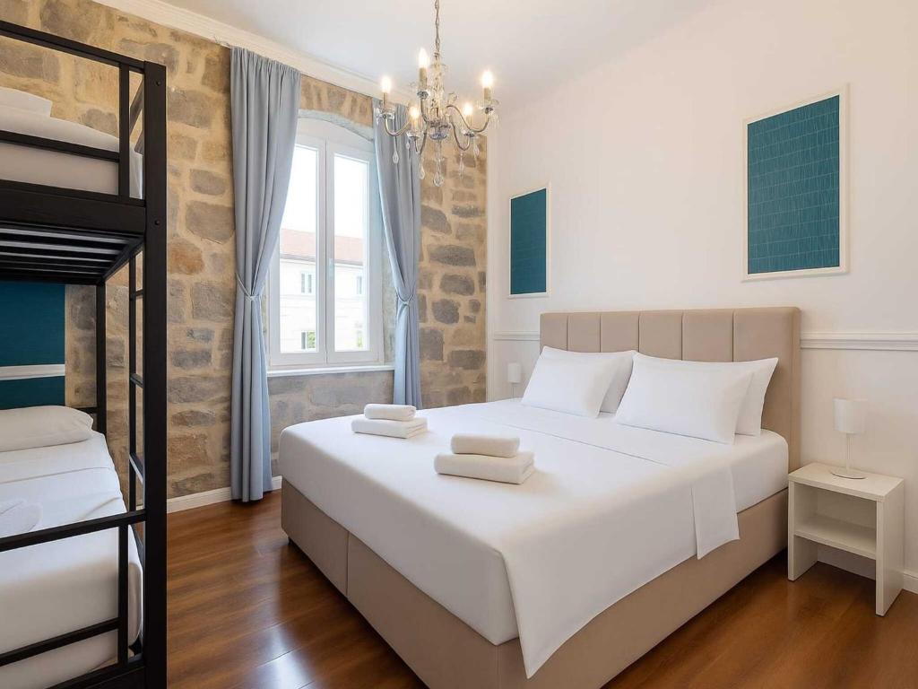 a bedroom with a large white bed with towels on it at Silver Gate Rooms-Diocletian's Palace in Split