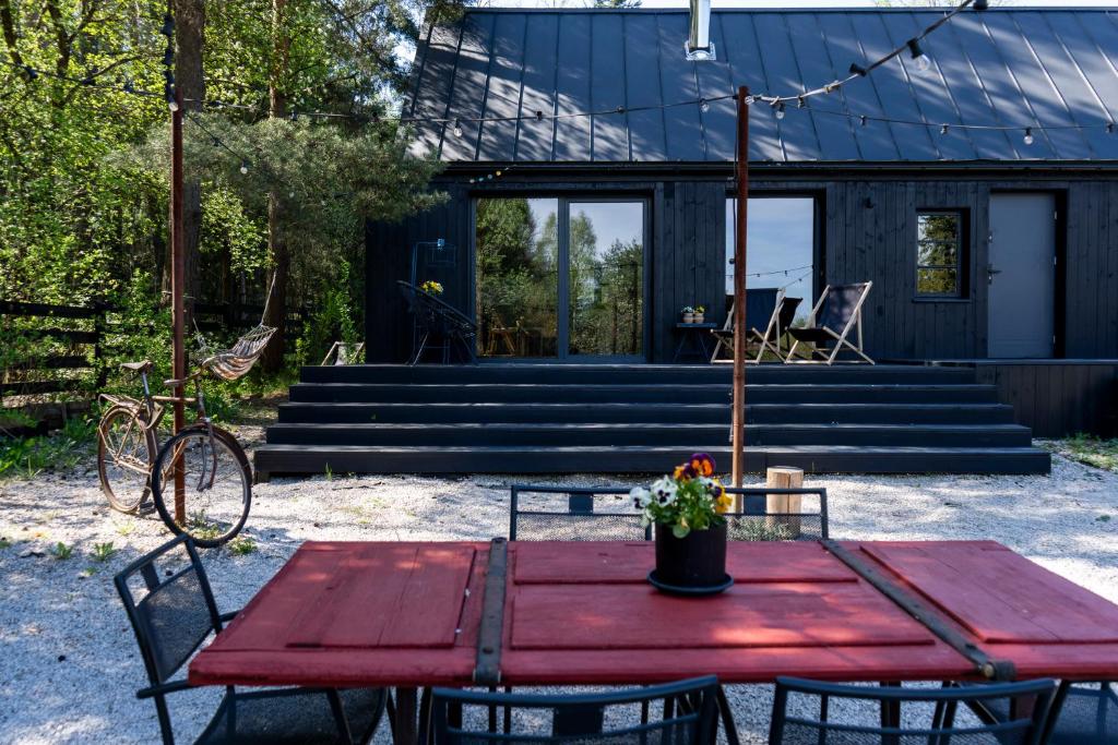 a red table and chairs in front of a house at Tu, Tam i Tamten Domek in Wojtyniów