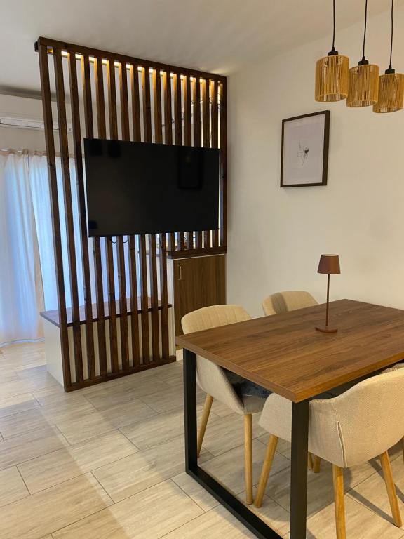 a dining room with a table and a flat screen tv at Apartma Ložice in Deskle