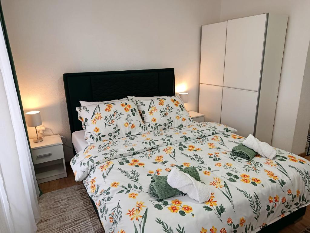 a bedroom with a bed with a floral bedspread at Travnik Memories Apartments in Travnik