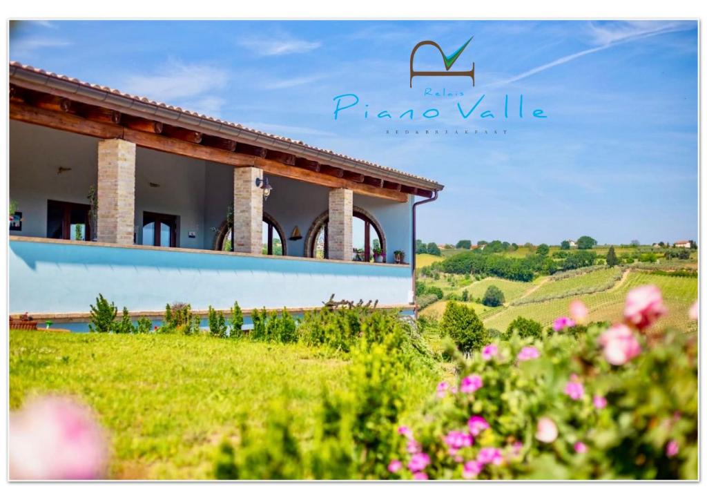 a house on a hill with flowers in front of it at Relais Piano Valle in Pollutri