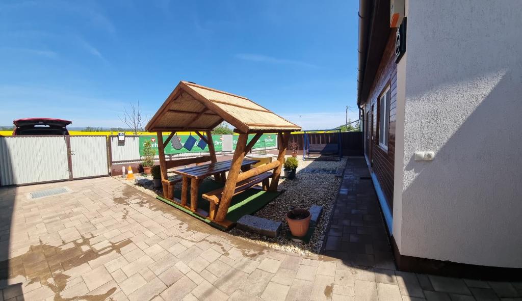 a wooden gazebo on the side of a building at HT Apartman in Mezőkövesd