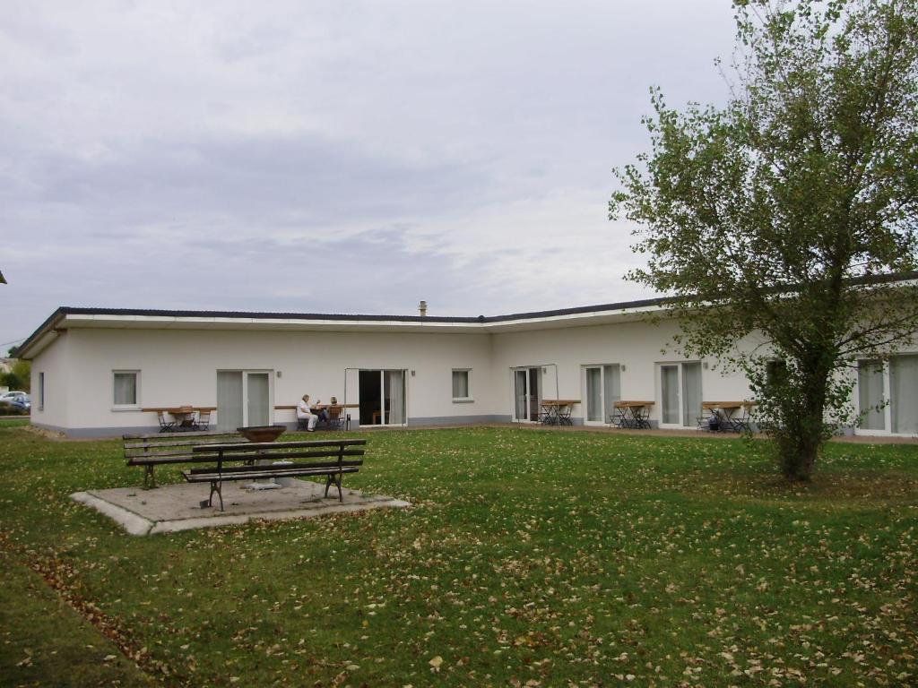 ein Gebäude mit einer Parkbank im Hof in der Unterkunft Pension am Sundhäuser See in Nordhausen