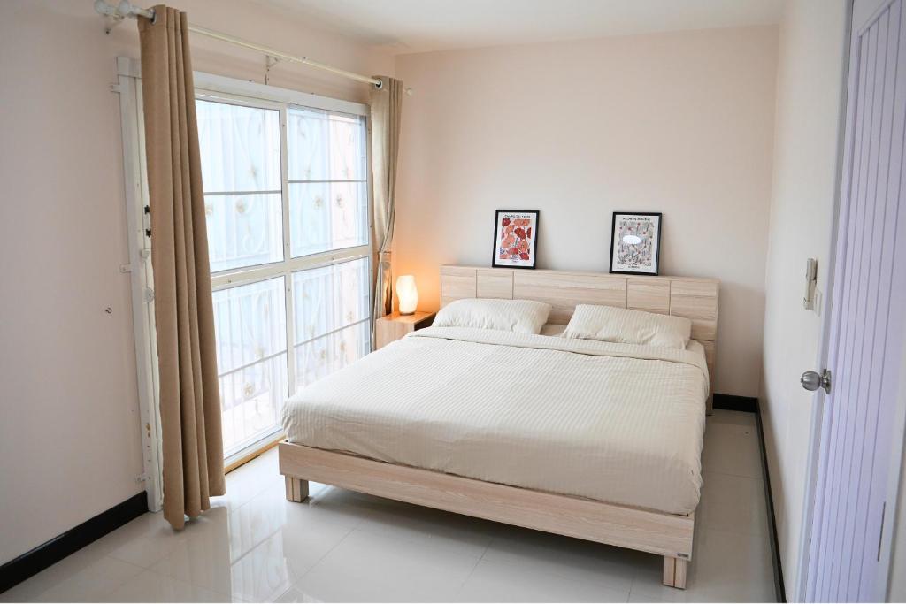 a bedroom with a bed and a large window at Walking distance Thunder Dome in Ban Bang Phang
