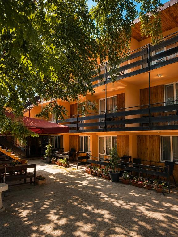 a large building with benches in front of it at Family Hotel Yulian in Kranevo