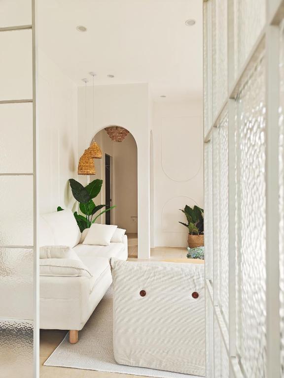 a living room with white furniture and a mirror at The Shores House-Royal Plams Tres by THE HOUSE in Dauis