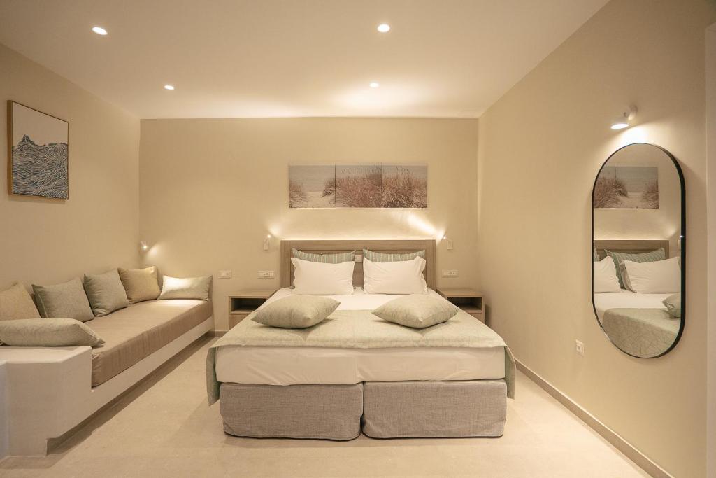 ein Schlafzimmer mit einem Bett, einer Couch und einem Spiegel in der Unterkunft Arhontou in Apollonia