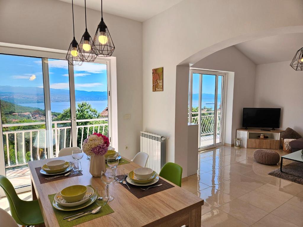 a dining room with a table and chairs with a view at Apartman Ruza 2 in Opric