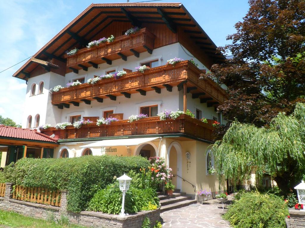 una casa con balcón y flores. en Pension Grünauhof, en Grünau im Almtal