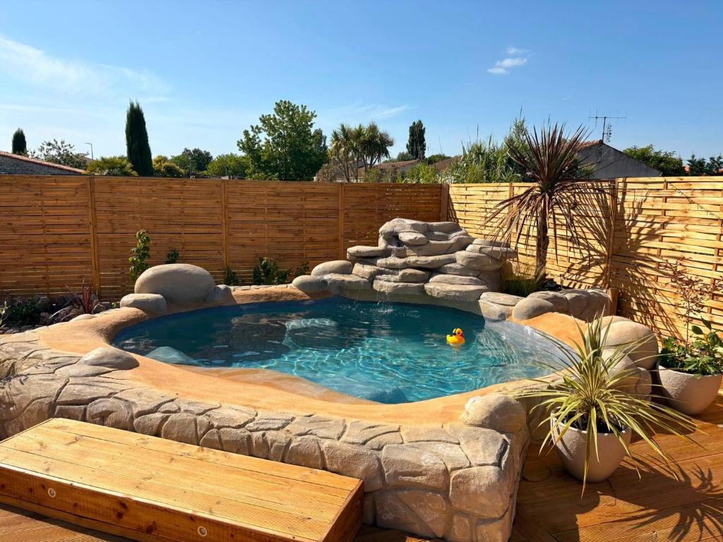 a small pool in a backyard with a wooden fence at Le Logis de la Gabirotte in Nieulle-sur-Seudre