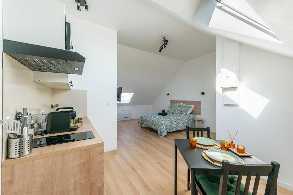 a kitchen and living room with a table and chairs at Casa 37 in Saint-Quentin
