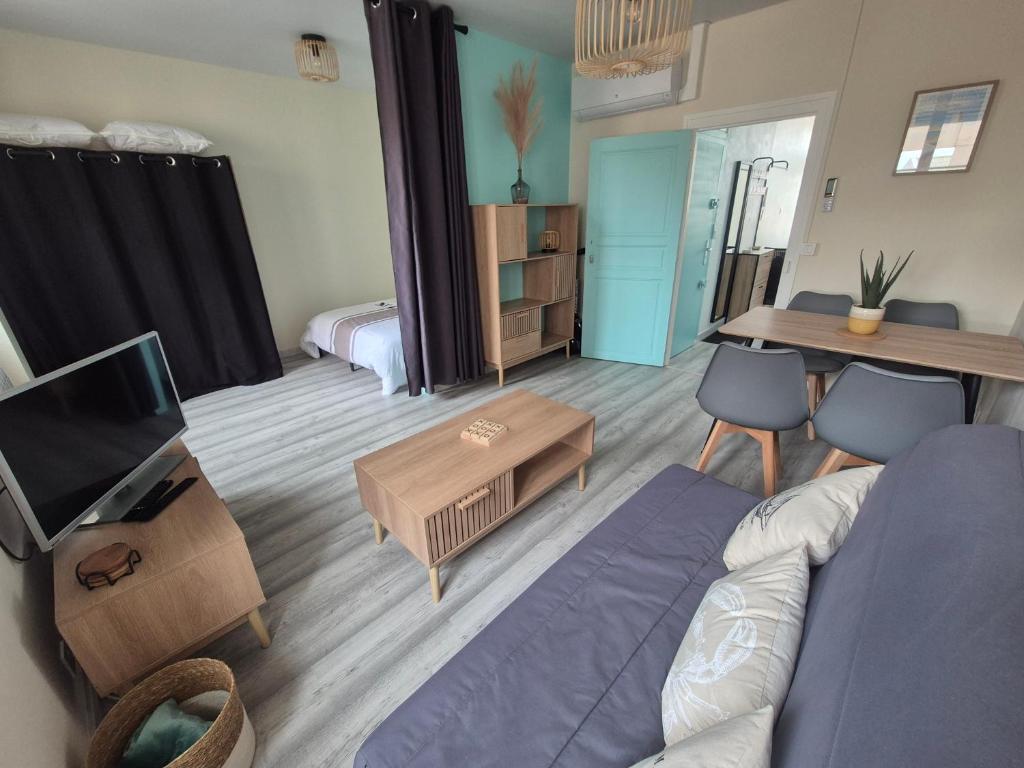 a living room with a couch and a tv at L'Escale Sablaise in Les Sables-d'Olonne