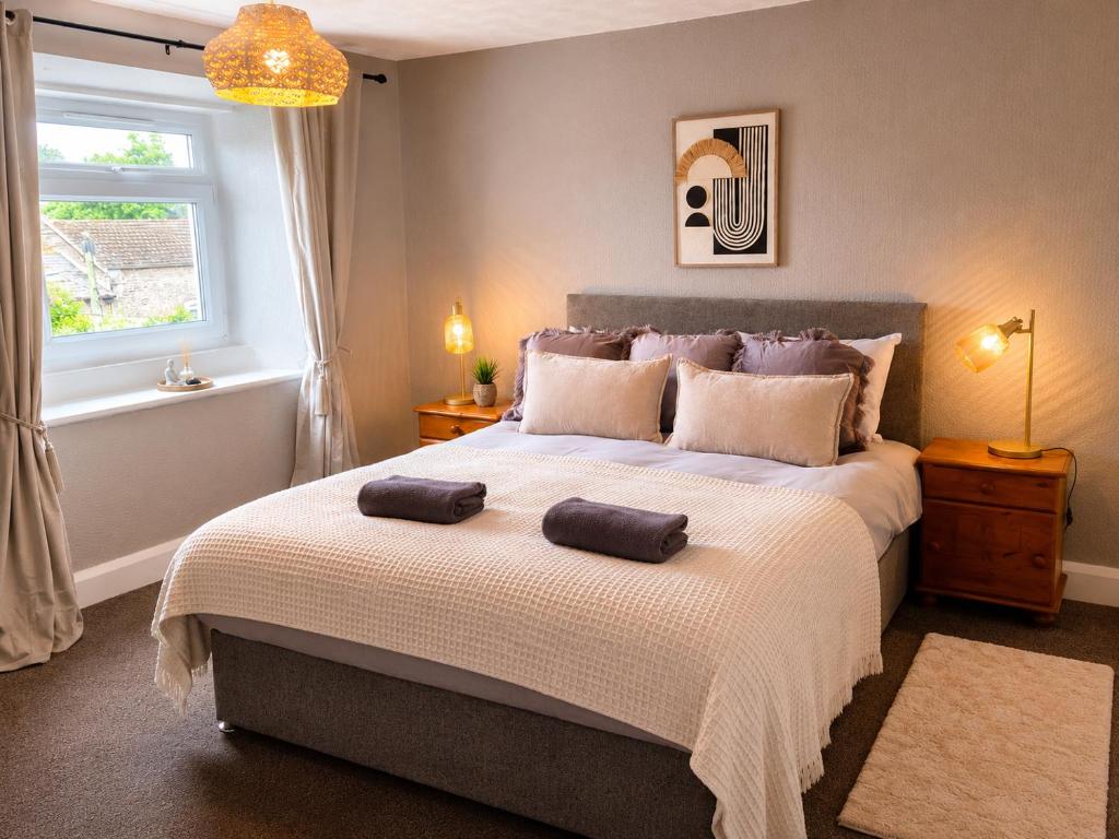 a bedroom with a large bed with two towels on it at The Flat in central Kirkby Stephen in Kirkby Stephen