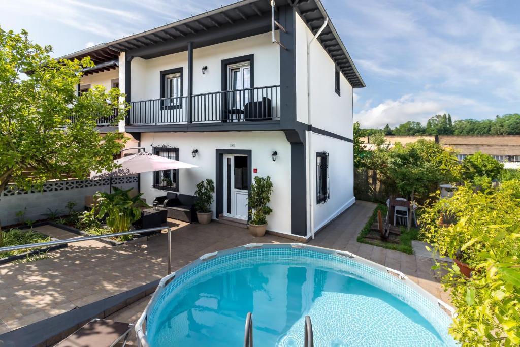 a villa with a swimming pool and a house at Casa independiente entre mar y montaña in Puente San Miguel