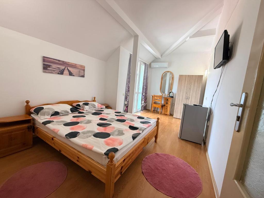a bedroom with a bed and a television in it at Guest House Orfey in Kranevo