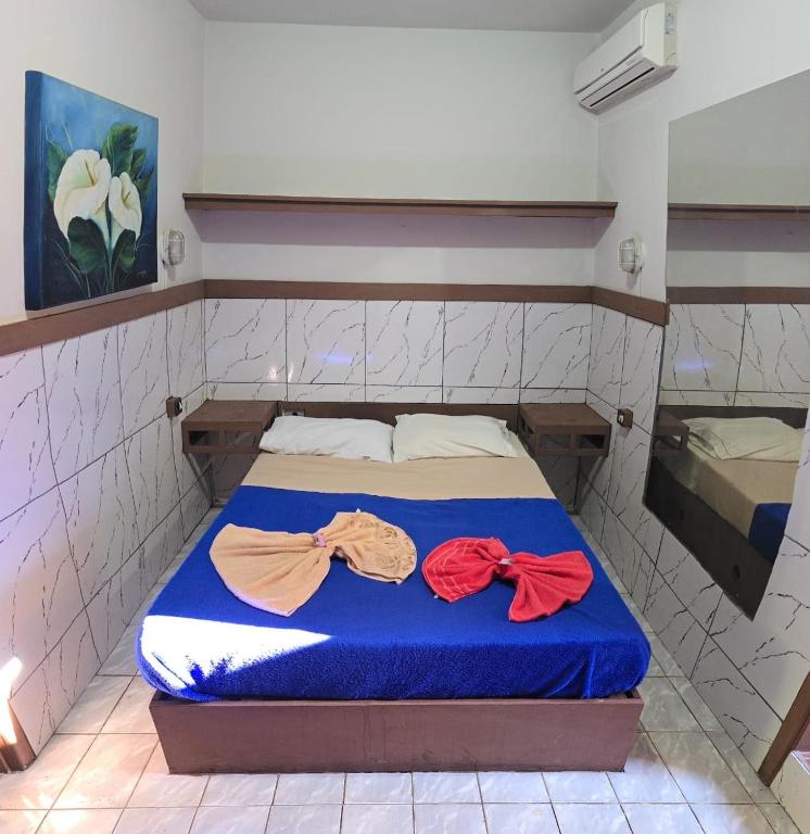 a bed in a room with two bows on it at Pousada Catuaí in Siqueira Campos