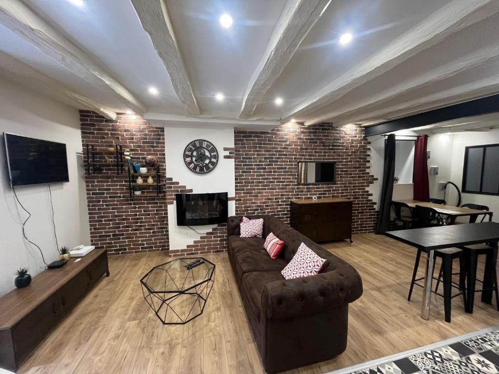 a living room with a couch and a brick wall at Appartement Limoges in Limoges