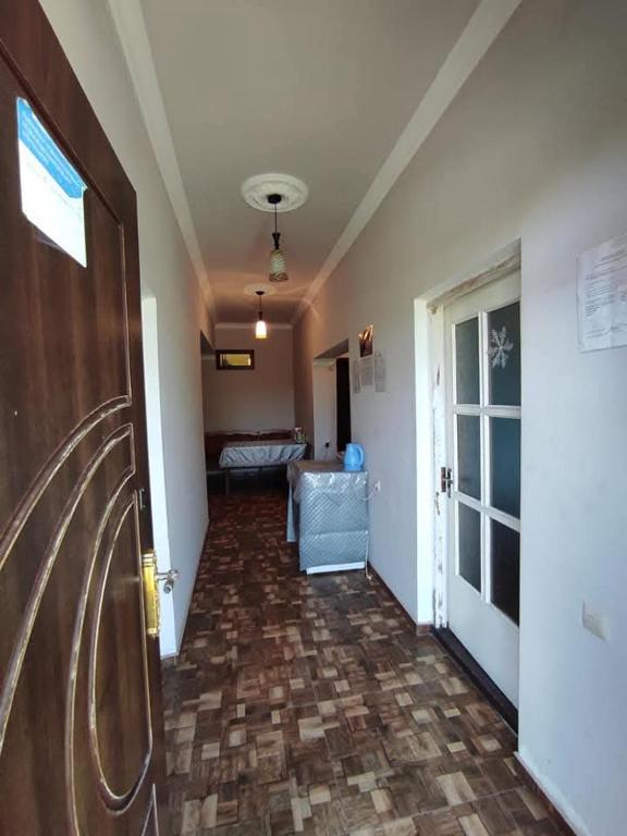 an empty hallway with a door and a room with a couch at Anna's guest house in Chambarak
