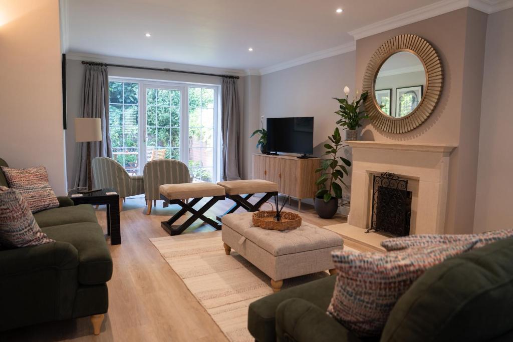 a living room with a fireplace and a mirror at Ivy House in Stockbridge