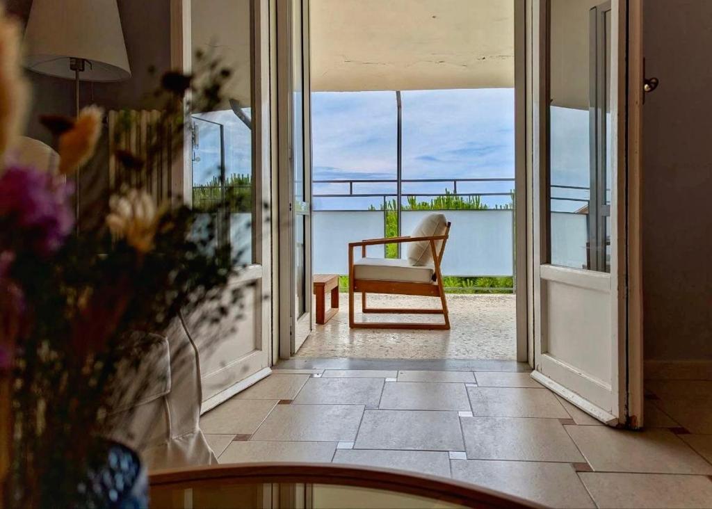 an open door to a balcony with a chair at Greto al Mare in Francavilla al Mare