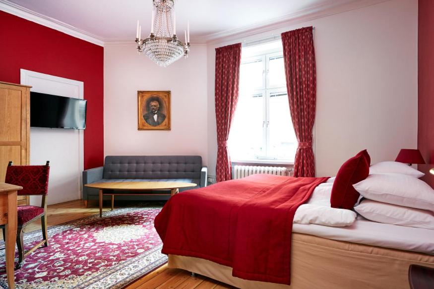a red bedroom with a bed and a couch at Hotel Hornsgatan in Stockholm