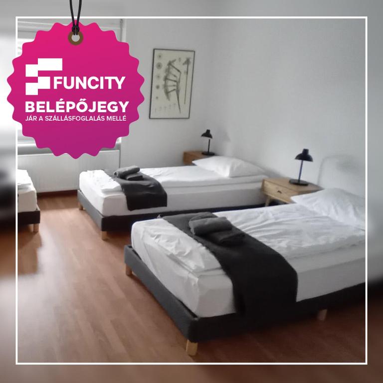 three beds in a room with a pink advertisement at Bükfürdő Bercsényi 13 apartmanház, Bükfalva in Bük