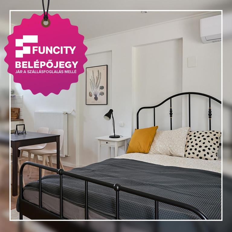 a bedroom with a black bed and a pink sign at Bükfürdő Kúria Apartman Stúdió, Bükfalva in Bükfürdő
