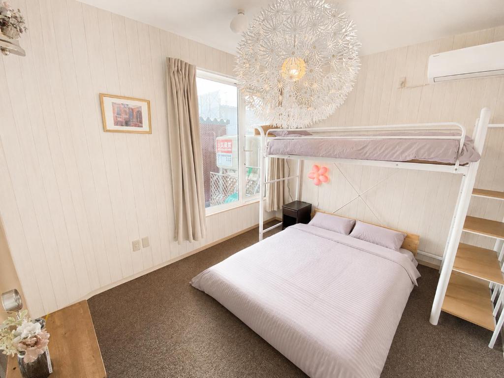 a bedroom with two bunk beds and a window at Yume House in Furano