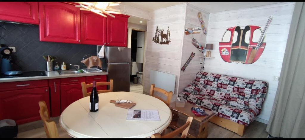 a kitchen with a table and red cabinets and a table and chairs at Casse blanche in Orcières