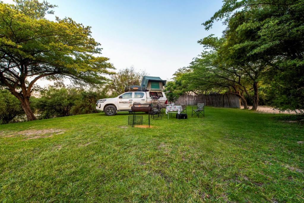 a car parked in a yard with a camper at Hakusembe River Campsite in Rundu
