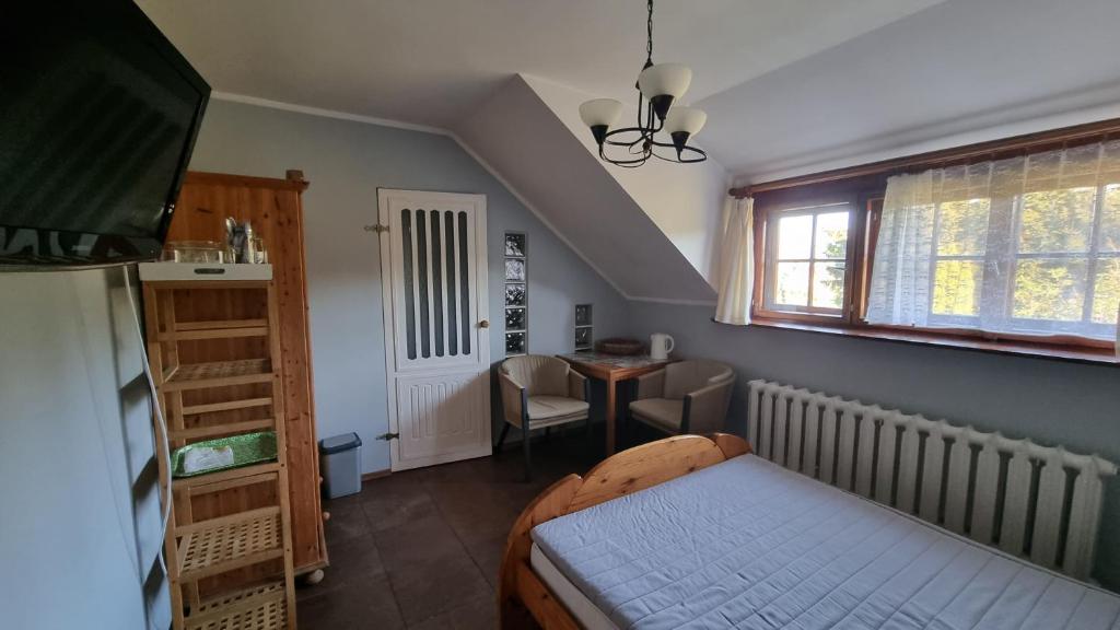 a bedroom with a bed and a desk and a window at Agroturystyka u Bogusi in Sarbinowo