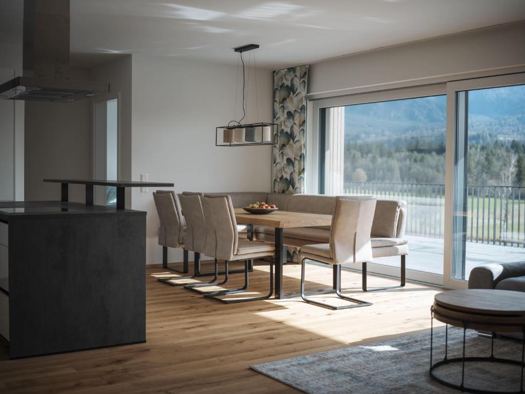 a kitchen and dining room with a table and chairs at Panorama-Lodge Mittagskogel in Ledenitzen
