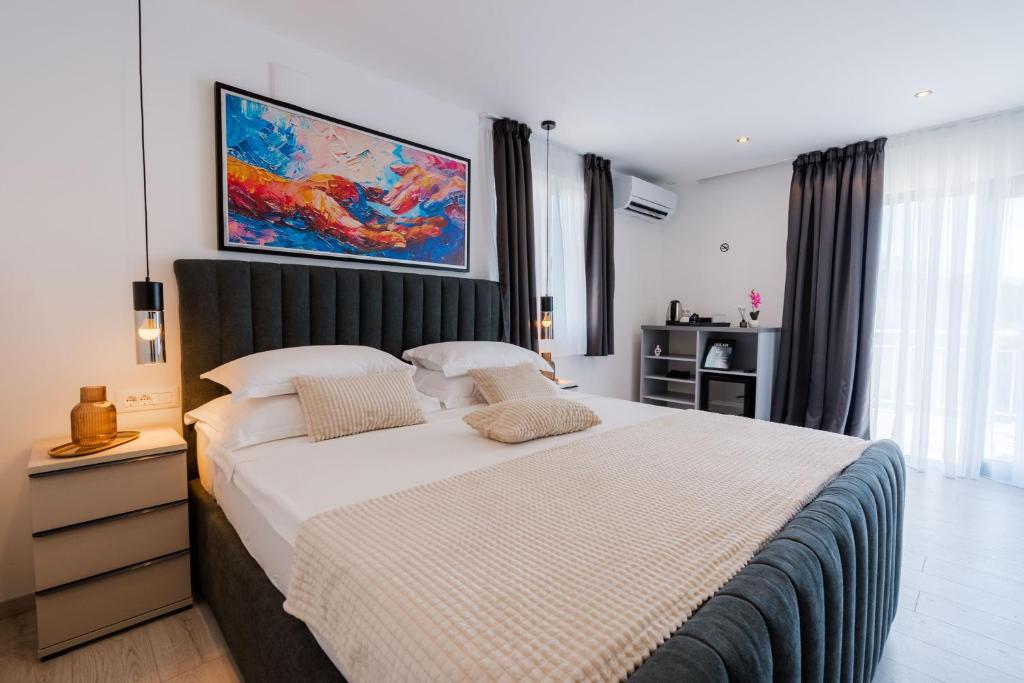 a bedroom with a large bed with a painting on the wall at Matej's rooms in Korčula