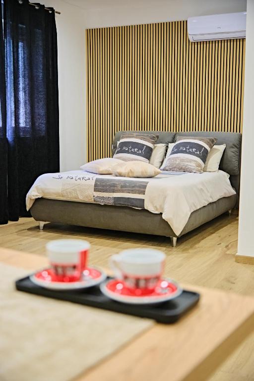 a bed in a room with two plates on the floor at RG MAISON - Room 35 in Morino
